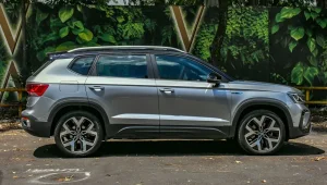 Volkswagen Taos 2025 prata com teto preto posicionado de lateral.