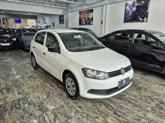 Volkswagen Gol branco à venda por até 45 mil reais, mostrado em um showroom com outros carros ao fundo, perfeito para quem busca economia e confiabilidade.