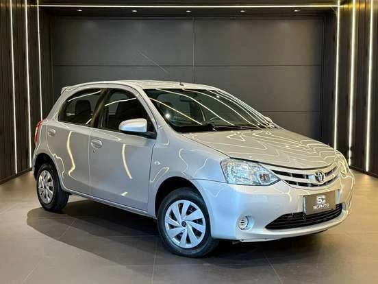 Toyota Etios prata em showroom, compacto econômico com ótimo desempenho e preço acessível até 55 mil reais, ideal para quem busca economia e praticidade.