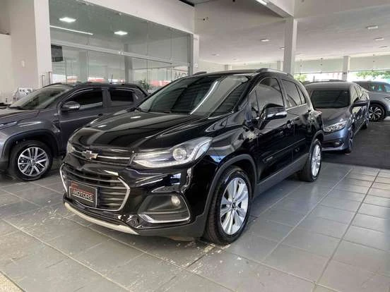 Imagem de um Chevrolet Tracker preto em uma concessionária, destacando seu design moderno e acabamento de qualidade, disponível por até 90 mil reais.