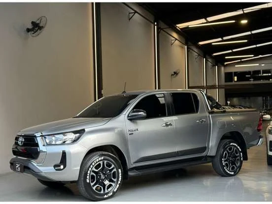 Toyota Hilux prata em showroom, destaque por seu design robusto e espaço interno, ótimo para quem busca uma caminhonete confiável até 200 mil reais.