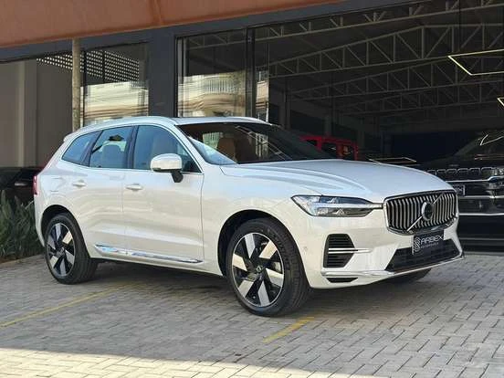 Volvo XC60 na cor branca estacionado na frente de uma loja, com design moderno, grade frontal distintiva e rodas elegantes, ideal para quem busca SUV de luxo.
