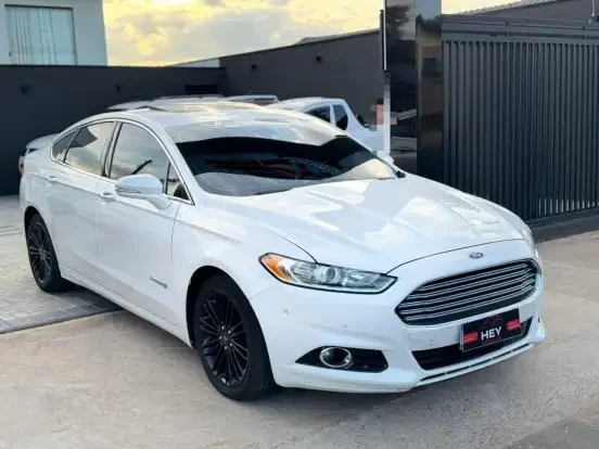Ford Fusion branco à venda por até 150 mil reais, preço acessível, excelente estado, com rodas pretas, ideal para quem busca um carro confortável e econômico.