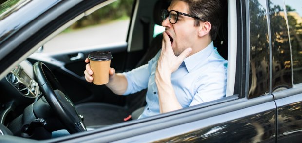 Young Man Drink Coffee Feeling Tired And Yawning While Driving A Car