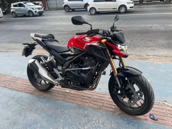 Motocicleta Honda CB 500F ABS vermelha estacionada na rua, ideal para quem busca motos até 50 mil com ABS.