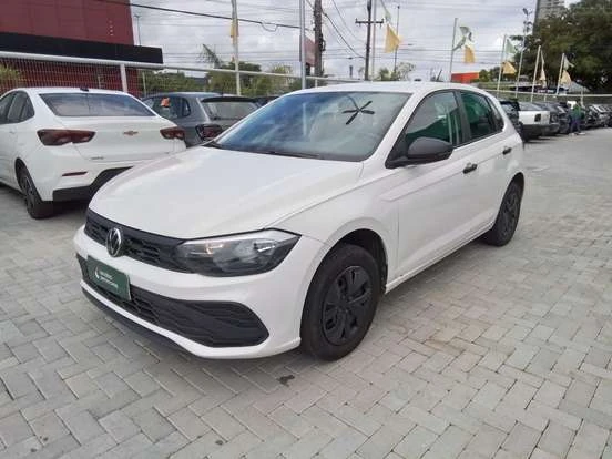 Volkswagen Polo branco estacionado em concessionária, em ambiente externo, com outros carros ao fundo e céu claro.