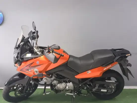 Suzuki V-Strom 650 ABS de cor laranja com design robusto, painel digital completo, pneus esportivos e características de aventura, ideal para longas viagens.