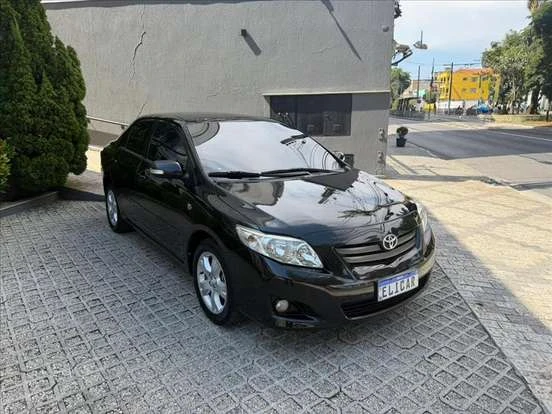 Carro Toyota Corolla preto por até 60 mil reais, estacionado na rua, com excelente estado de conservação e acabamento moderno.