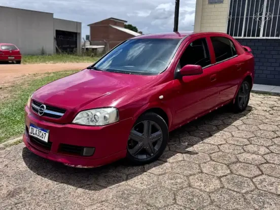 Carro Chevrolet Astra vermelho à venda por até 25 mil reais, ótimo estado, com rodas escuras e documentação regular, ideal para quem busca um veículo econômico e confiável.