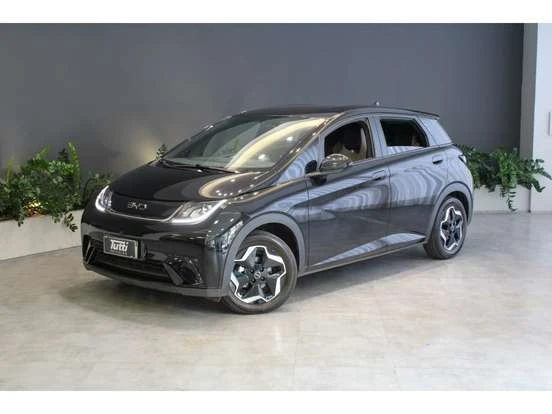 Imagem do carro BYD Dolphin na cor cinza escuro, em exposição em um ambiente moderno, destacando seu design compacto e inovador, ideal para quem busca veículos elétricos acessíveis até 150 mil.