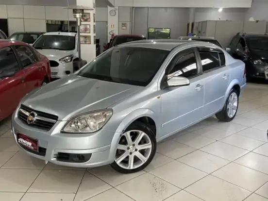 Imagem de um Chevrolet Vectra prata em excelente estado, disponível para venda por até 30 mil reais, localizado em uma concessionária moderna.