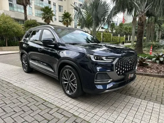 Imagem do SUV CAOA Chery Tiggo 8 na cor preta, estacionado em ambiente urbano com árvores e edifícios ao fundo, destacando seu design moderno e elegante.