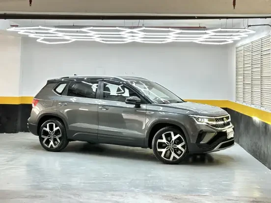 Volkswagen Taos preto estacionado em ambiente moderno com iluminação de LED e decoração na parede, perfeito para quem busca SUV compacto de até 280 mil.