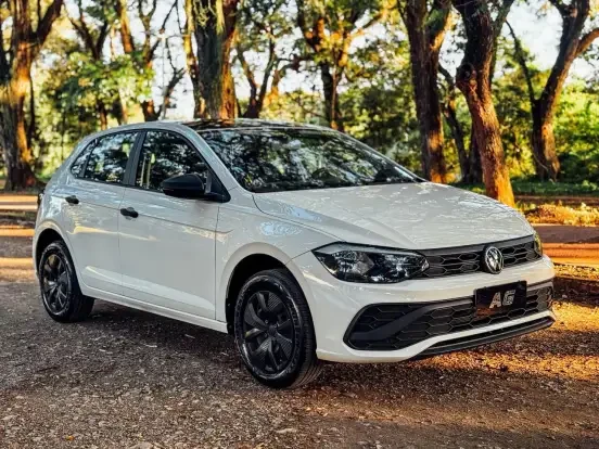 Volkswagen Polo branco em estacionamento cercado por árvores, destaque para seu design moderno e preço acessível até 100 mil reais.